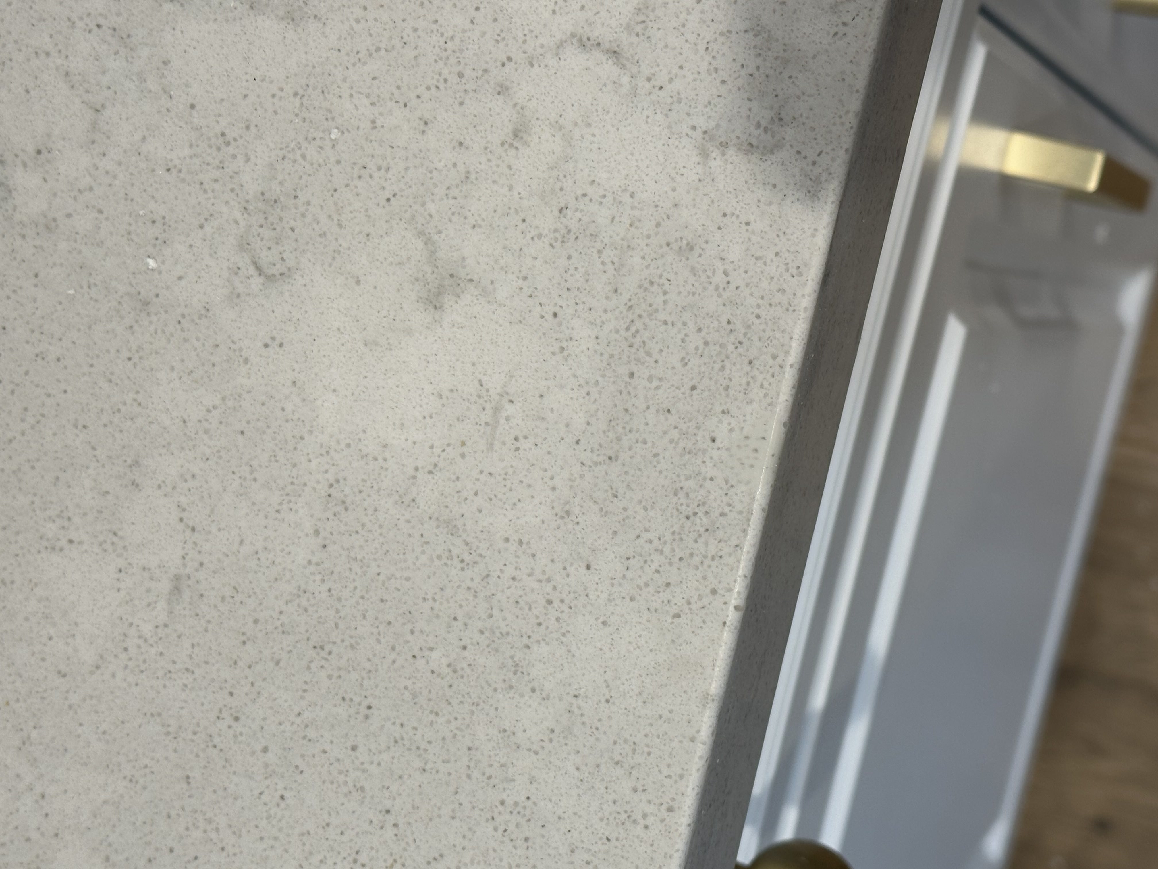 Speckled quartz countertop after chip repair, filled solid and leveled