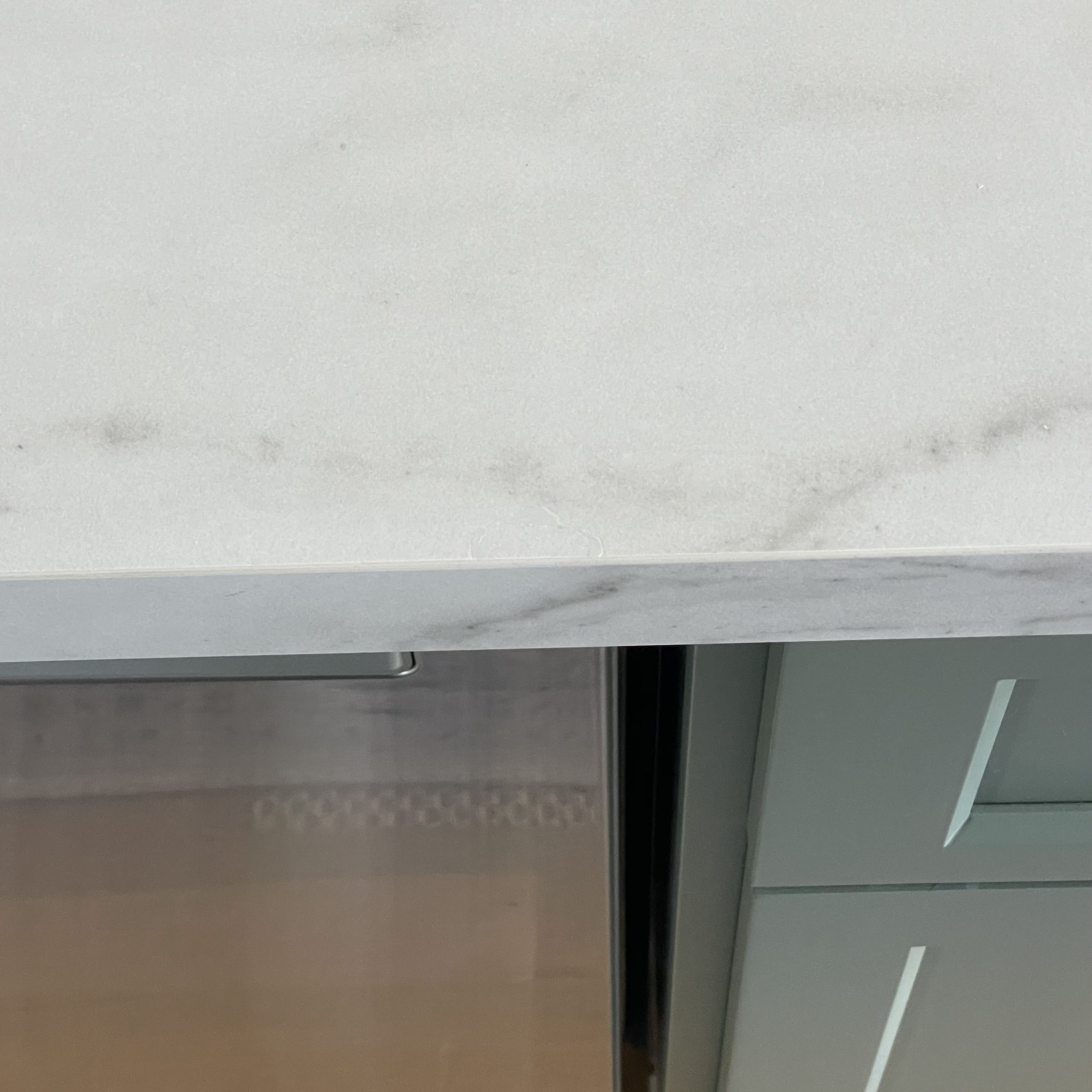 Quartz countertop edge after old filler was cleaned out and the chip refilled flush